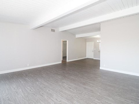 an empty living room with white walls and wood floors