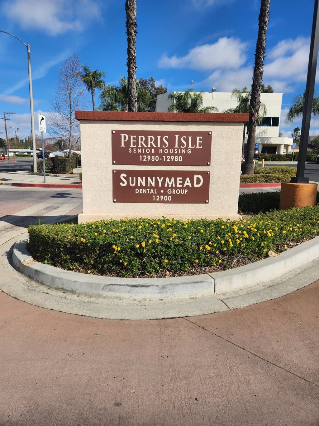 A sign for Perris Isle Senior Housing and Sunnymead Dental Group.