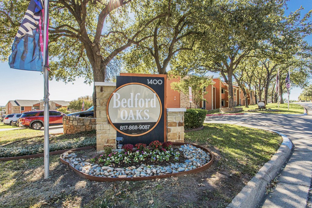 a sign apartments in front of a street with a flag