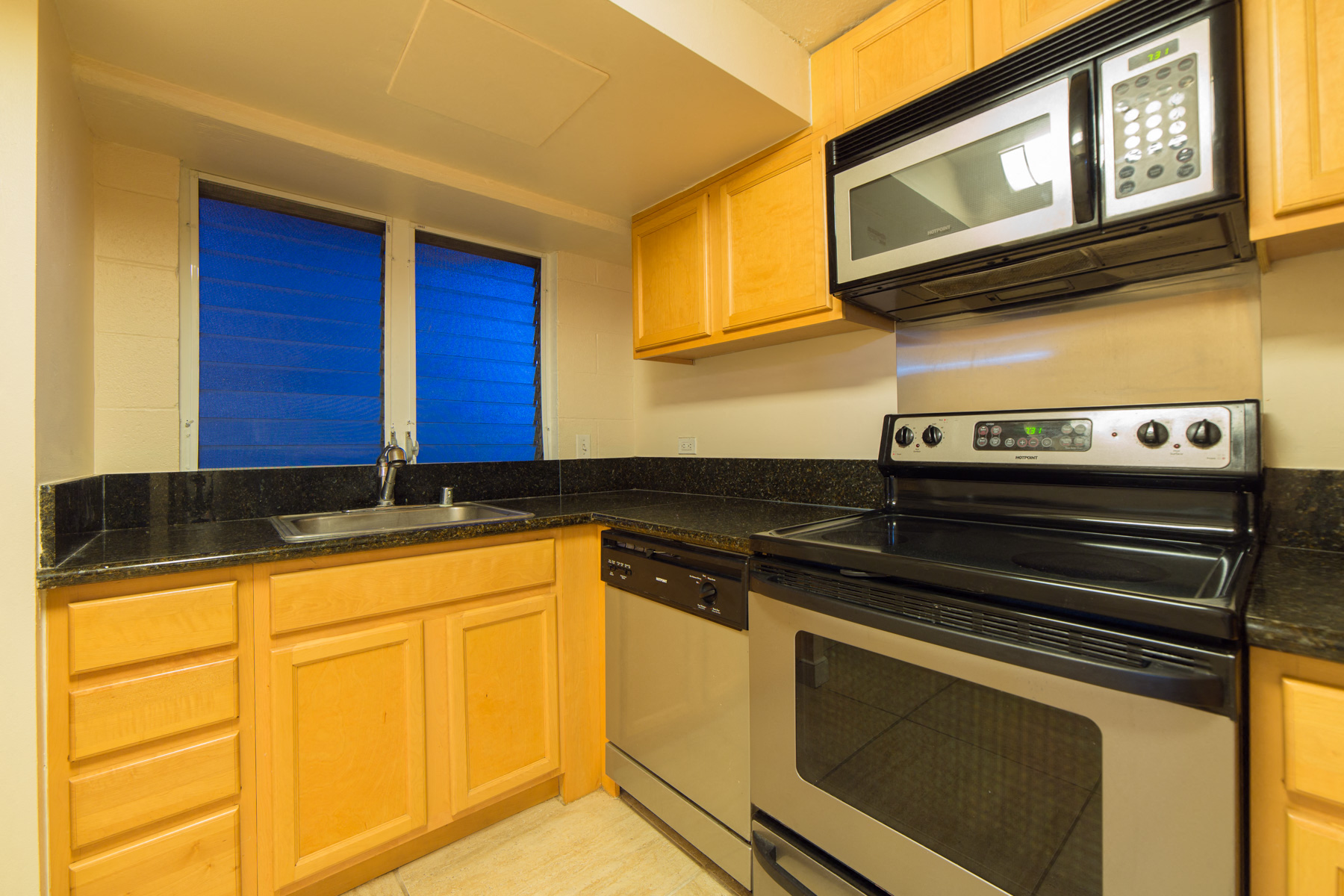 Napili Towers kitchen area with appliances, cabinets, and counters