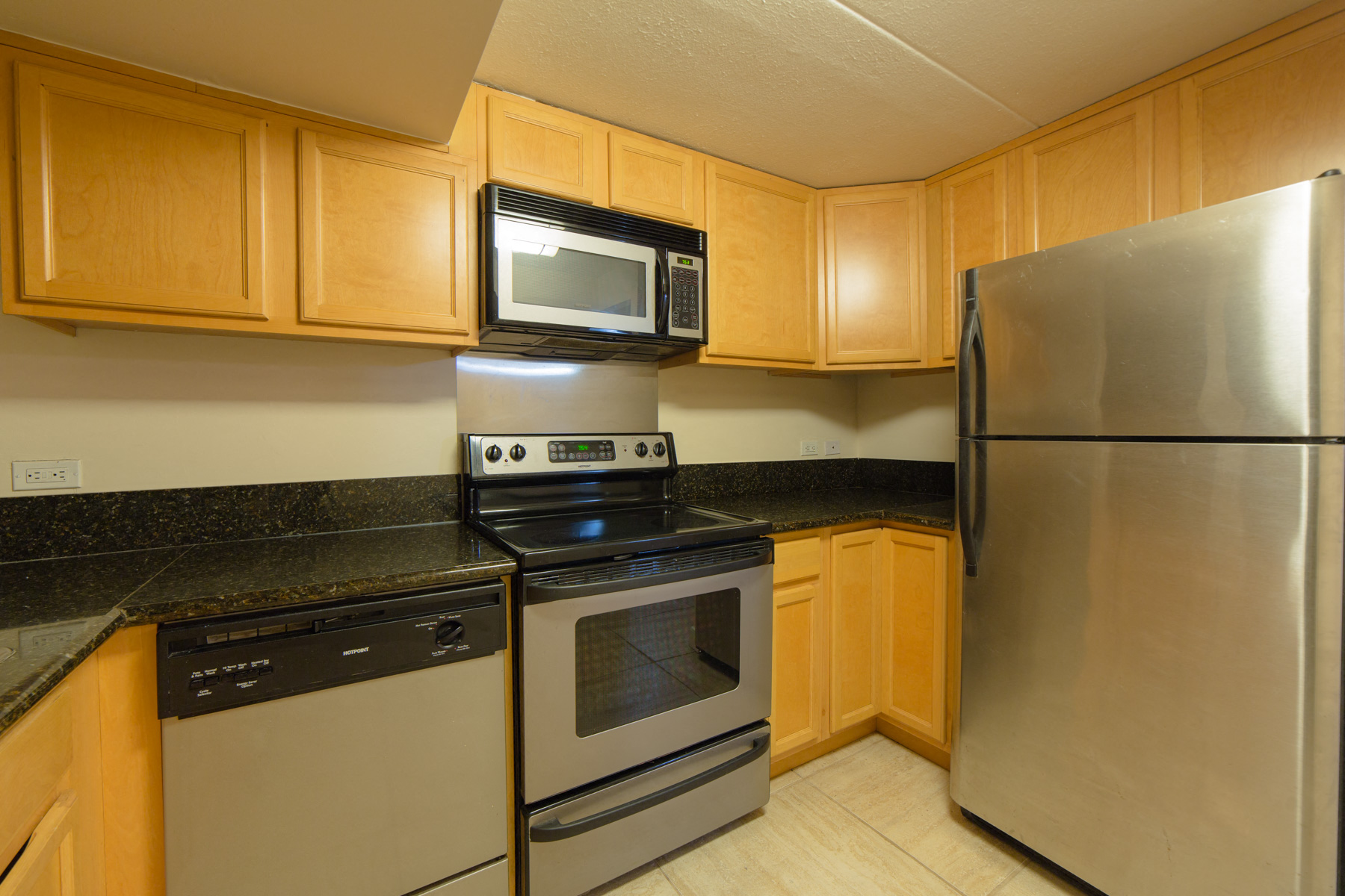 Napili Towers kitchen area with appliances, cabinets, and counters