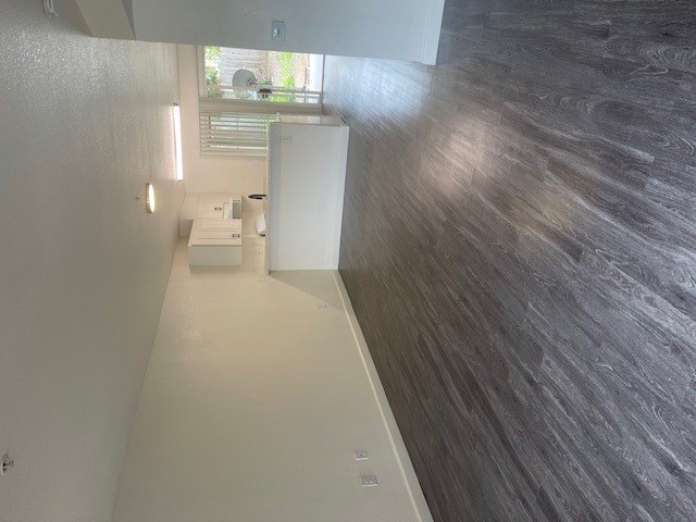 A bathroom with a white tub and a window.