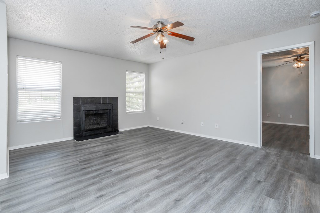 A room with a fireplace and a ceiling fan.