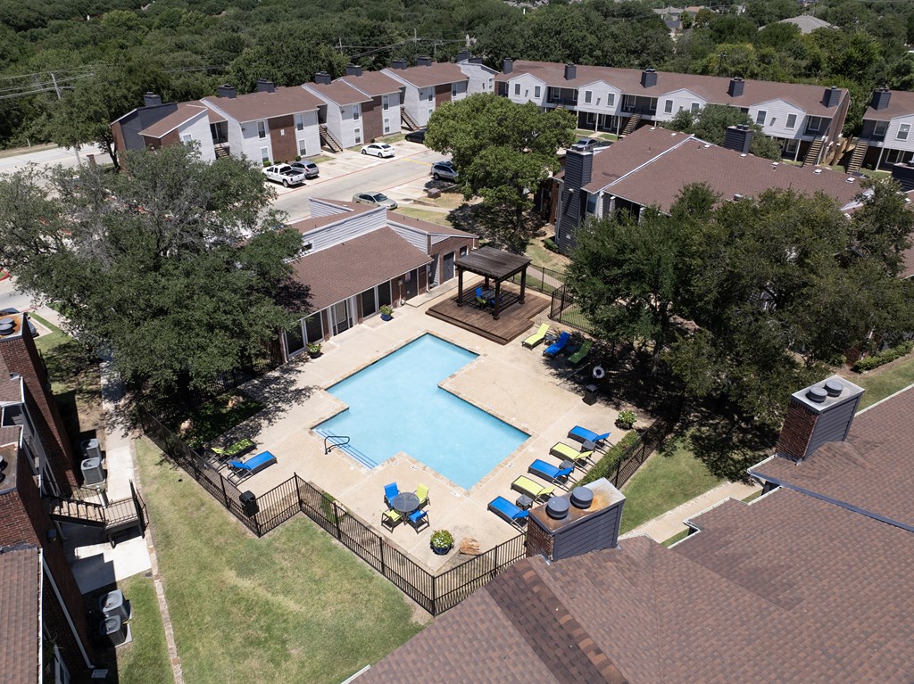 A pool surrounded by a fence and chairs.