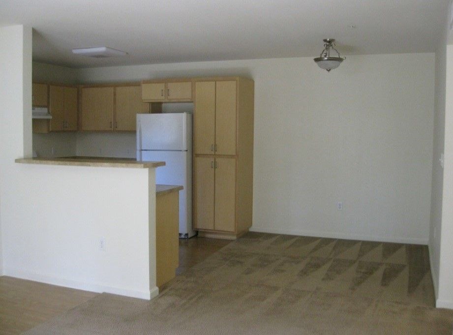 A kitchen with a white refrigerator and wooden cabinets.