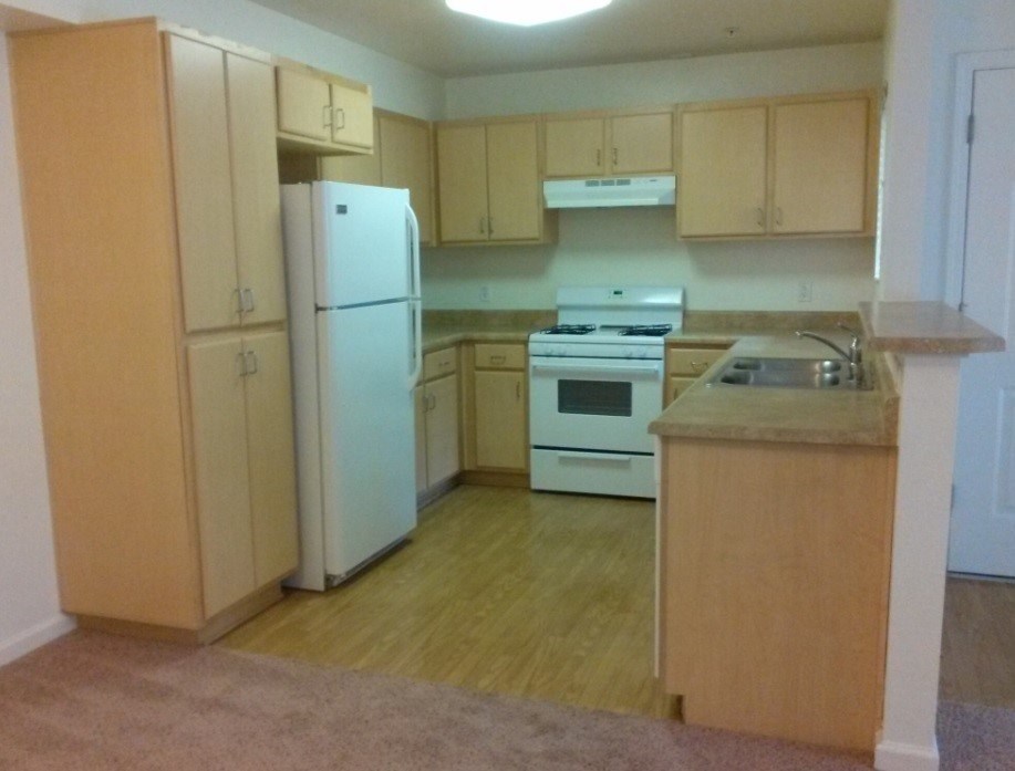 A kitchen with a white refrigerator and white stove.