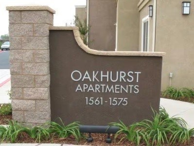 A sign for Oakhurst Apartments with the address 1561-1575.
