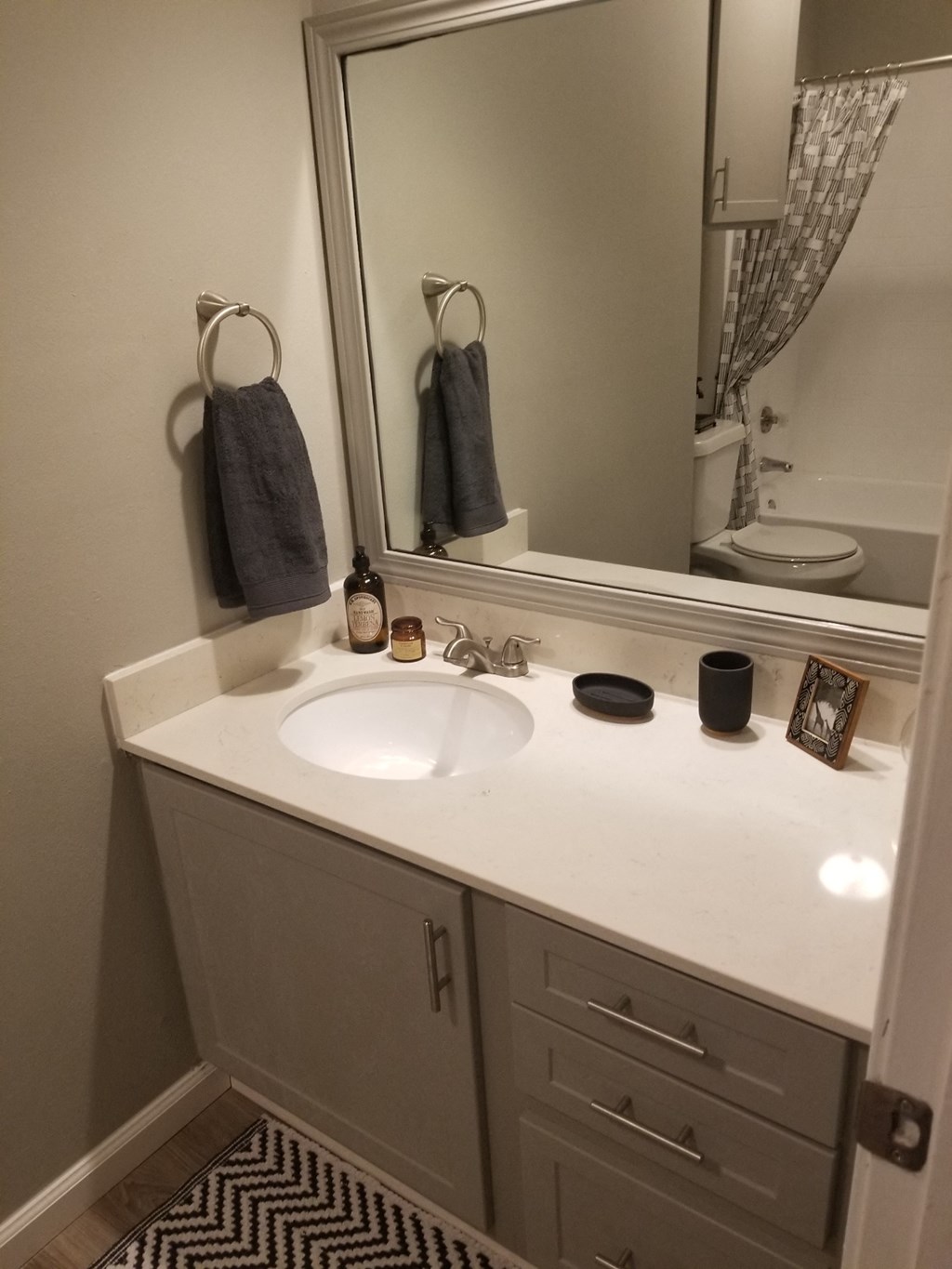 Oakwood Creek Apartments bathroom sink, mirror, and counter with cabinets