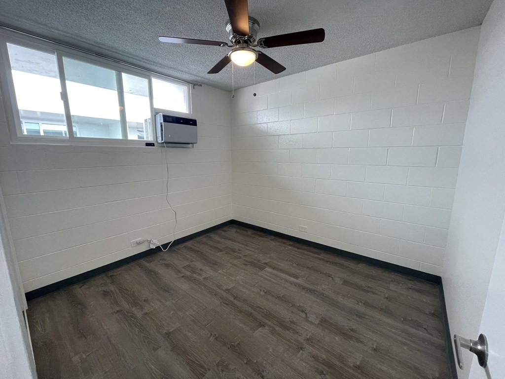 an empty room with a ceiling fan and a window