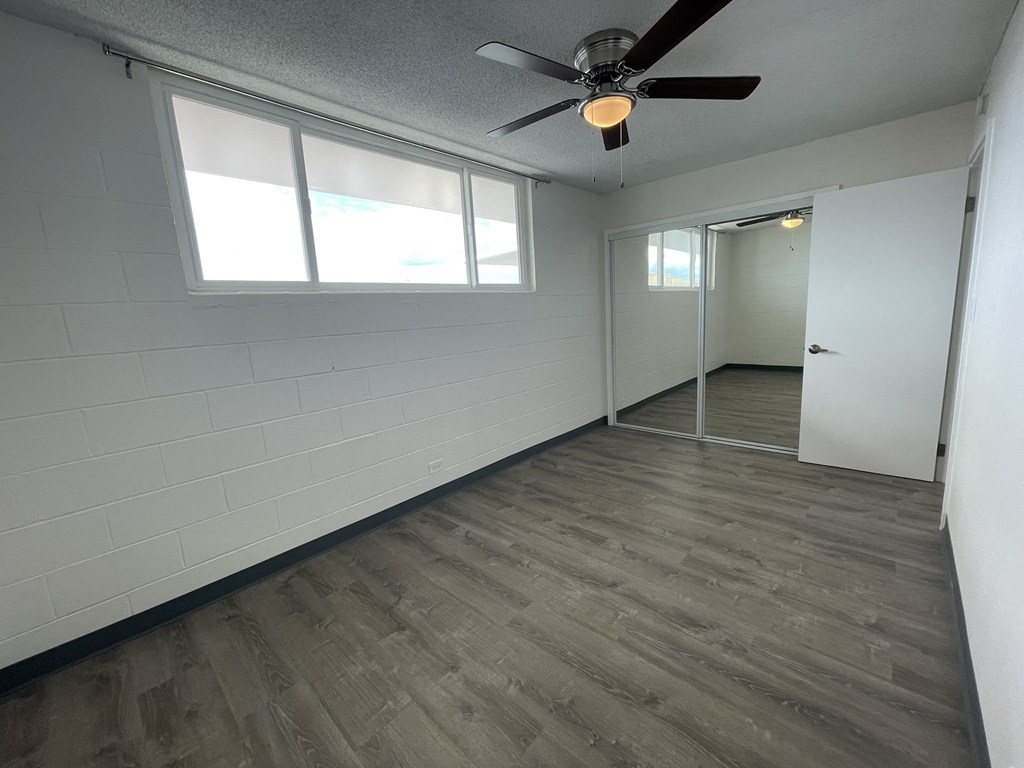 an empty room with a ceiling fan and a window