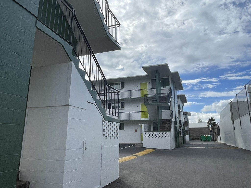 the side of a building with stairs and a cloudy sky