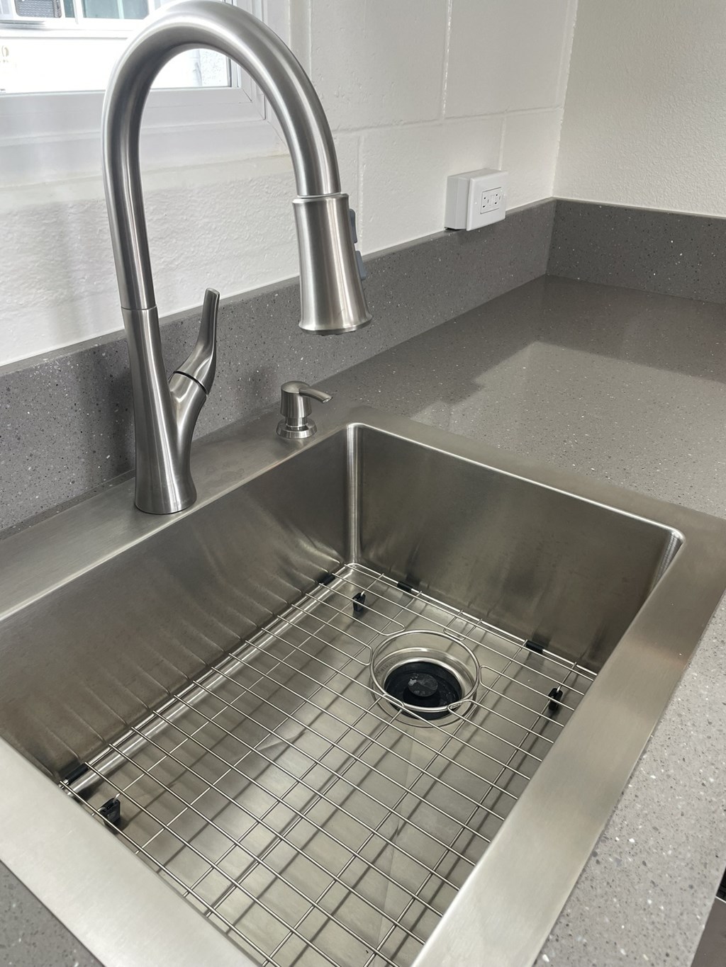 a stainless steel sink in a kitchen with a chrome faucet