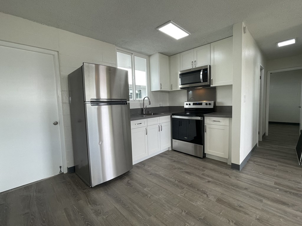 a kitchen with white cabinets and a stainless steel refrigerator