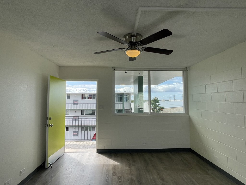 an empty room with a ceiling fan and a window