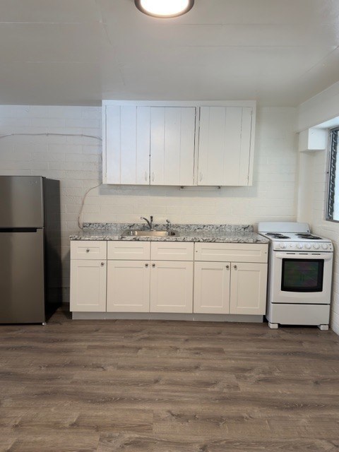 A kitchen with white cabinets and a stainless steel refrigerator.