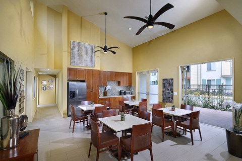 a dining room with tables and chairs and a kitchen