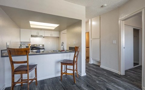 a kitchen with a bar and two chairs