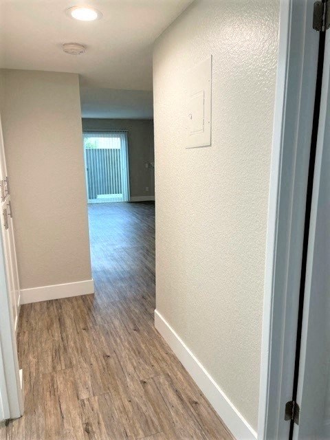 a hallway wiPeachgrove Apartments Hallwayth a wooden floor and a window