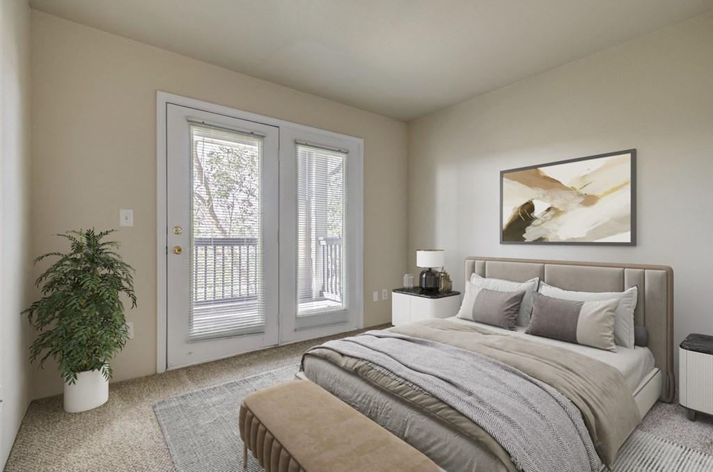 A bedroom with a bed, nightstand, and a plant.
