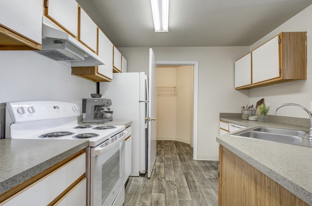 A kitchen with a white stove and a white refrigerator.