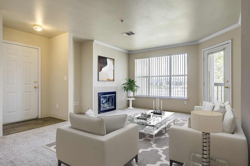 A living room with a white couch, a coffee table, and a painting on the wall.