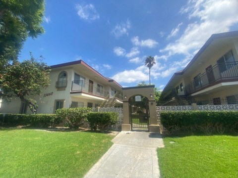 an apartment building with a lawn and a sidewalk