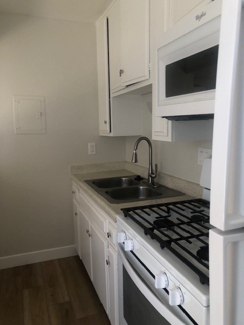 A kitchen with a white stove and microwave.