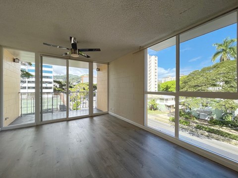 an empty living room with sliding glass doors to a balcony
