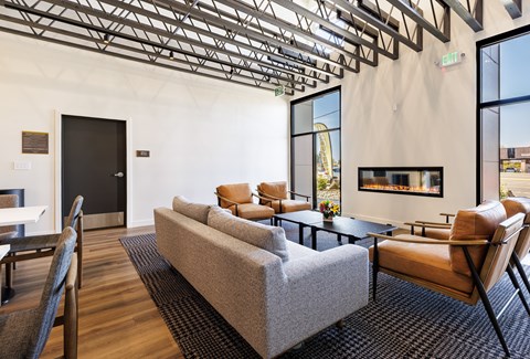 A living room with a grey couch and a fireplace.