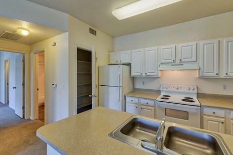 A kitchen with white cabinets and a stainless steel sink.