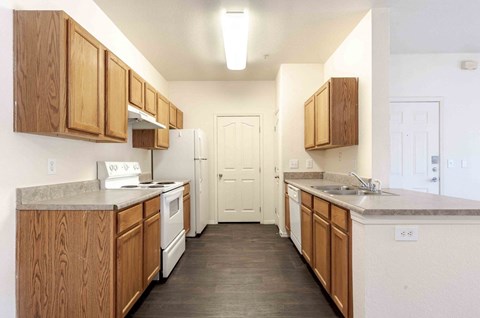 A kitchen with wooden cabinets and a white fridge.