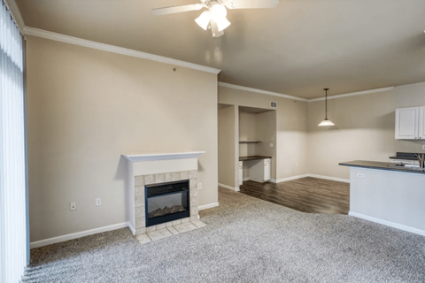 A living room with a fireplace and a ceiling fan.