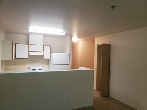 a kitchen with white cabinets and a white refrigerator and a door