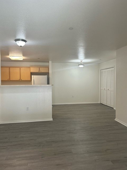 A kitchen with white cabinets and a white fridge with a countertop.
