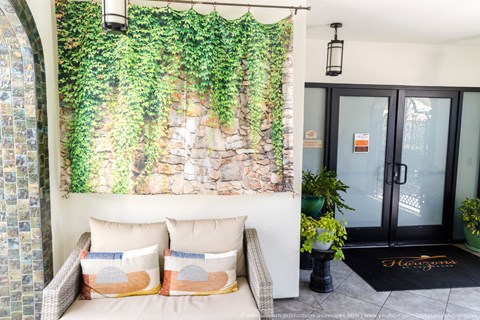 A living wall with greenery and a couch in front of it.