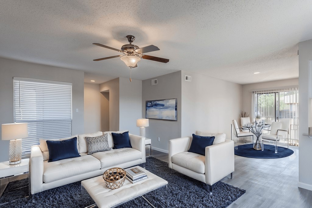 A living room with a white couch and a ceiling fan.