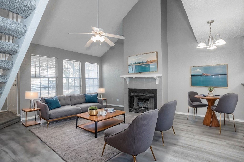 A living room with a grey couch, a coffee table, and a fireplace.