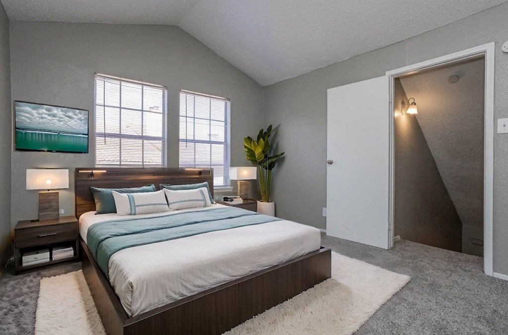A bedroom with a large bed and a painting on the wall.