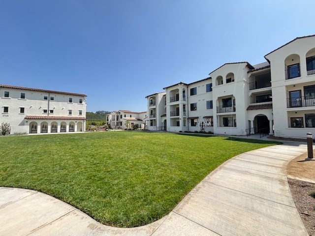 A large white building with a green lawn in front.