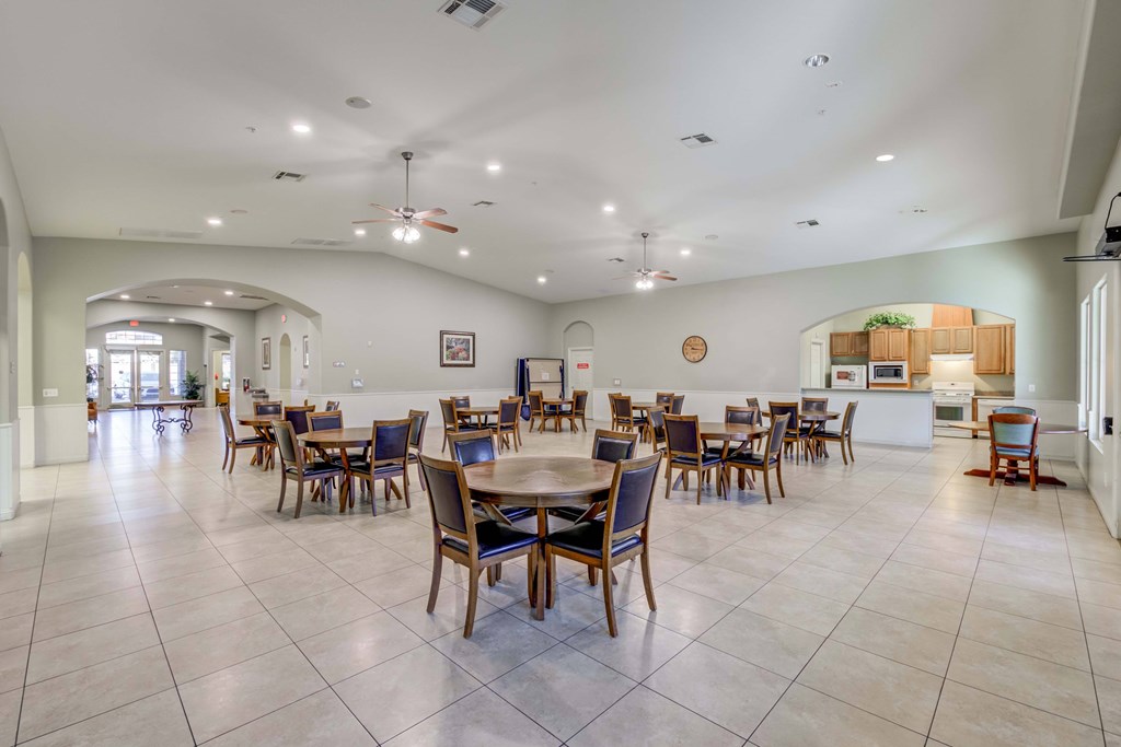 A spacious dining room with a large table and chairs.