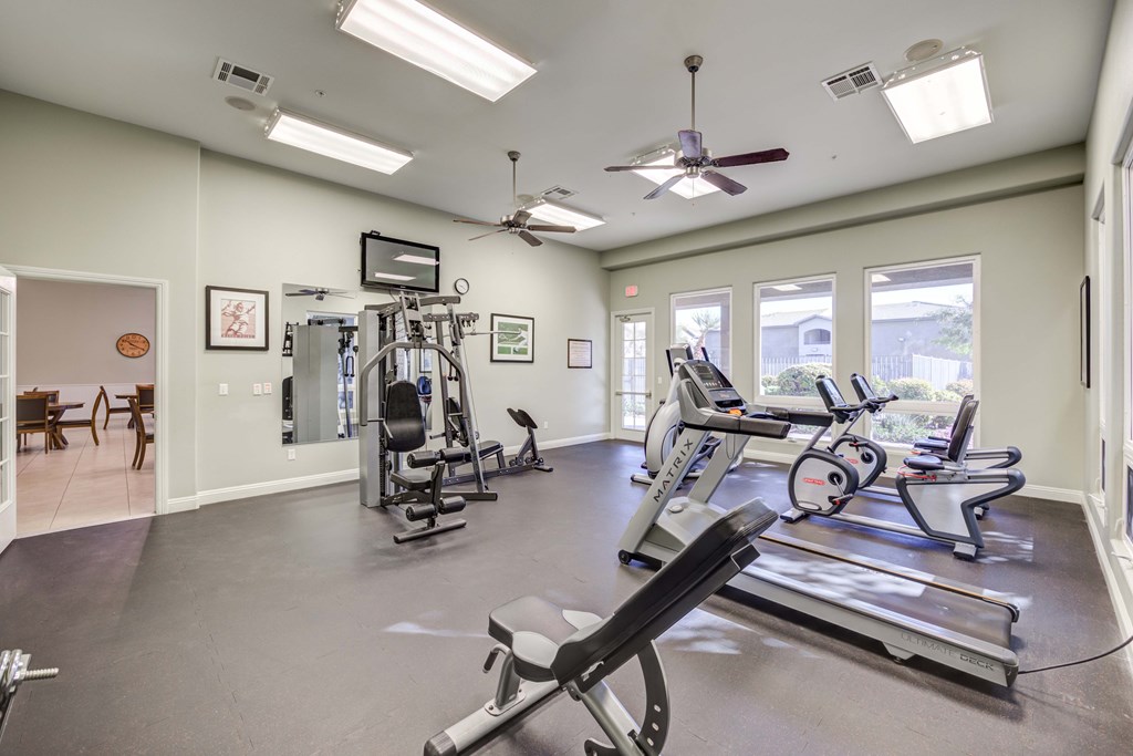 A spacious gym with treadmills, elliptical machines, and a weight machine.