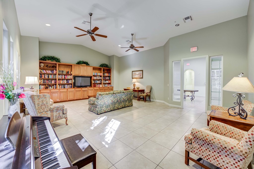 A living room with a piano and a bookcase.