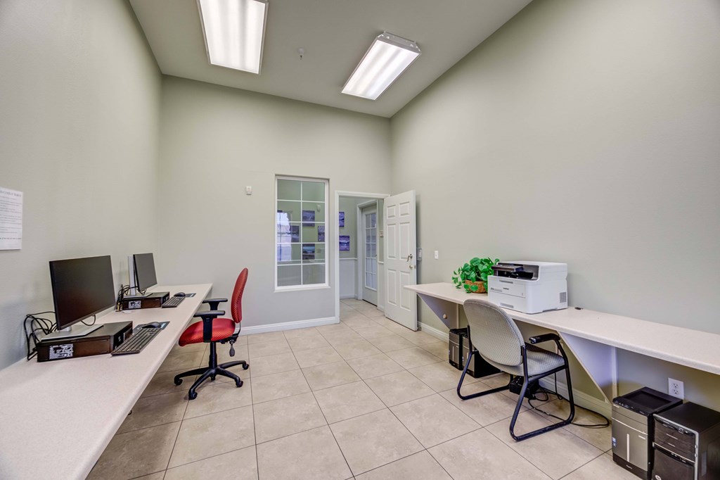 A room with a white desk and a red chair.