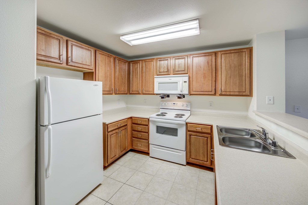 A kitchen with wooden cabinets and white appliances.
