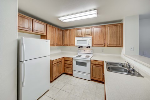A kitchen with wooden cabinets and white appliances.