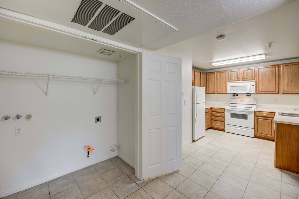 A kitchen with white appliances and wooden cabinets.