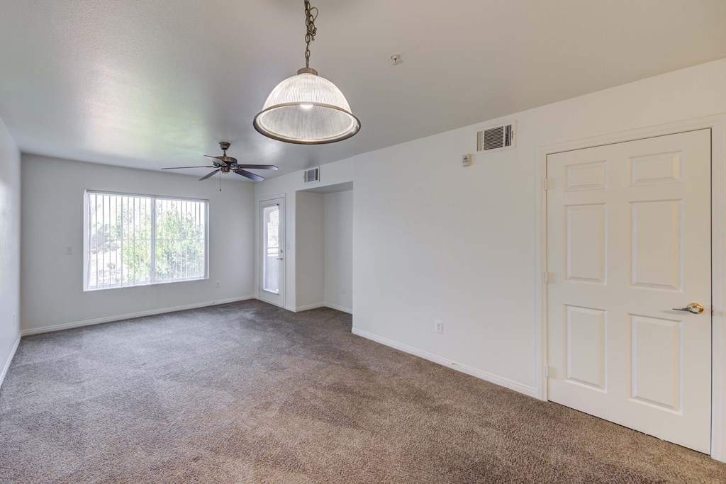 A room with a ceiling fan and a door.