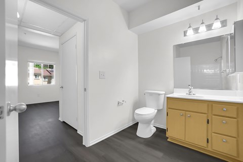 A bathroom with a toilet, sink, and mirror.
