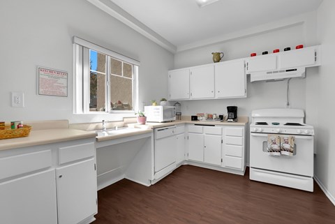 A kitchen with white cabinets and a stove top oven.