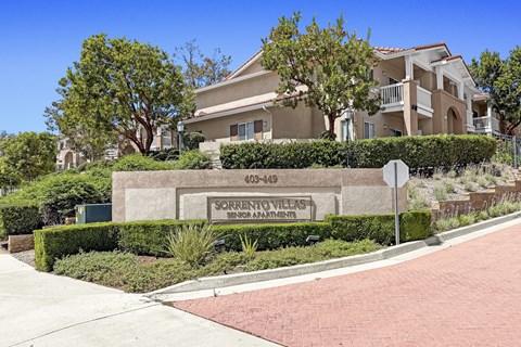 A sign for Sorrento Villas is in front of a building.